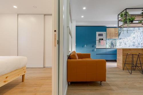1 dormitorio con 1 cama y 1 silla naranja en Amazing Setúbal, en Setúbal