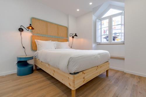 a bedroom with a large bed with a wooden headboard at Amazing Setúbal in Setúbal