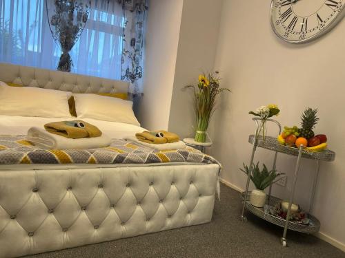 1 dormitorio con 1 cama con reloj en la pared en Apartment Luxe FREE WIFI, FREE PARKING, FREE NETFLIX en Friern Barnet
