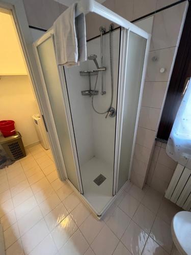 La salle de bains est pourvue d'une douche avec une porte en verre. dans l'établissement Appartamento Civico 23, à Brescia