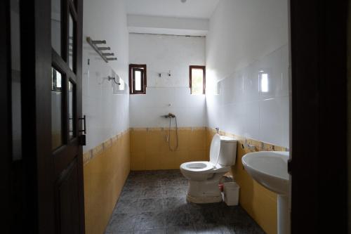 La salle de bains est pourvue de toilettes et d'un lavabo. dans l'établissement Happy Rest By Chill House, à Unawatuna