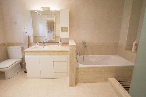 een badkamer met een bad, een wastafel en een toilet bij Catalunya Casas Port Aventura,Golf, Costa Dorada at your doorstep in Reus