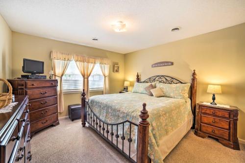 a bedroom with a bed and a dresser and a television at Oak Island Home with Fenced Yard, Walk to Long Beach in Oak Island