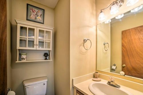 a bathroom with a sink and a toilet and a mirror at Oak Island Home with Fenced Yard, Walk to Long Beach in Oak Island