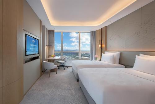um quarto de hotel com duas camas e uma televisão em Shenzhenair International Hotel em Shenzhen