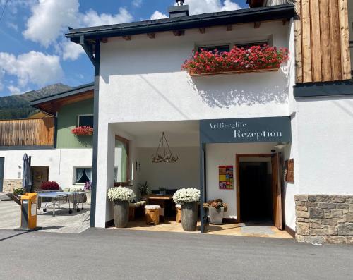 a white building with a sign that says hydration at ArlBerglife Ferienresort in Pettneu am Arlberg