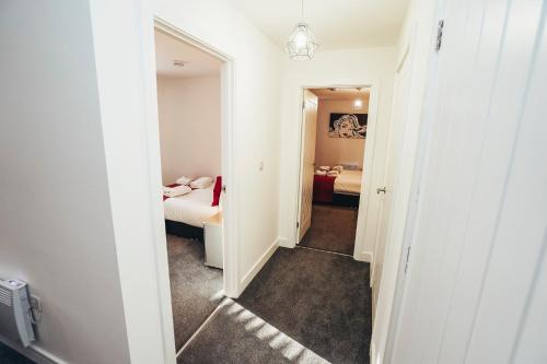 a hallway with a mirror and a bedroom at The Stay Company, Phoenix Court in Nottingham