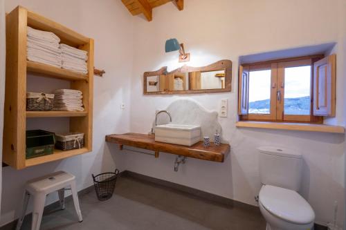 een badkamer met een toilet, een wastafel en een raam bij Casa Manuela in Ribera Baja