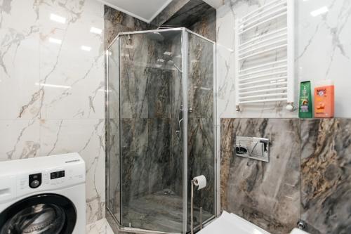 a bathroom with a washing machine in a shower at Luxury Apartment in Chişinău