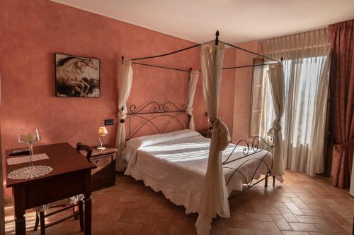 ペトリニャーノにあるB&B Villa Barbarossaのベッドルーム(天蓋付きベッド1台、テーブル、デスク付)