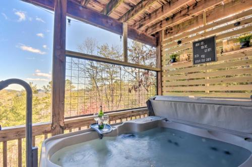a bath tub in a room with a large window at Lakemont Mtn Cabin with Game Room and Hot Tub! in Lakemont