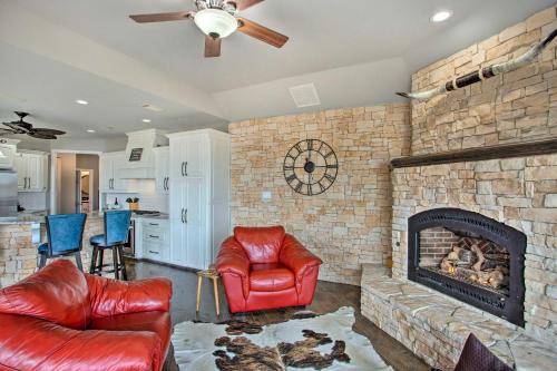 a living room with a brick fireplace and leather chairs at Lakefront Little Elm Home with Private Pool! in Little Elm