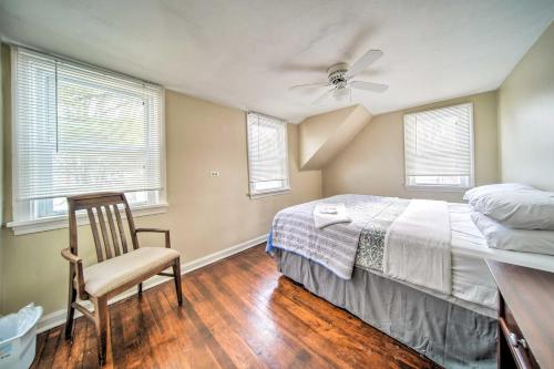 a bedroom with a bed and a chair and windows at Eastlake Vacation Rental Near Lake Erie! in Eastlake