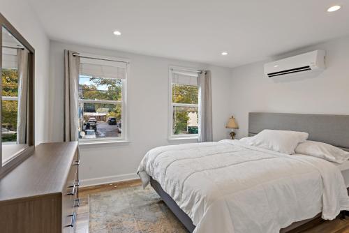 a white bedroom with a large bed and windows at Boutique Blue 2 bedroom Old Town House in Alexandria