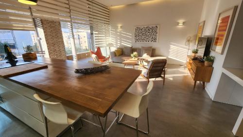 - un salon avec une grande table et des chaises en bois dans l'établissement White Night by Holyguest, à Tel Aviv