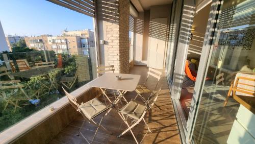 - un balcon avec une table blanche et des chaises dans l'établissement White Night by Holyguest, à Tel Aviv