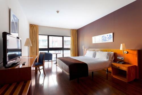 a hotel room with a bed and a television at Hotel Viladomat in Barcelona