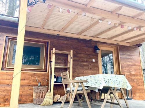 a wooden cabin with a table and chairs on a porch at Cinke cottage, nest in nature in Kismaros