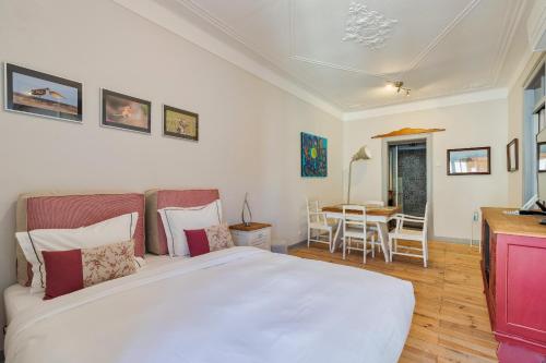 a bedroom with a large white bed and a table at Carmo´s Residence Art Apartments 2º in Setúbal