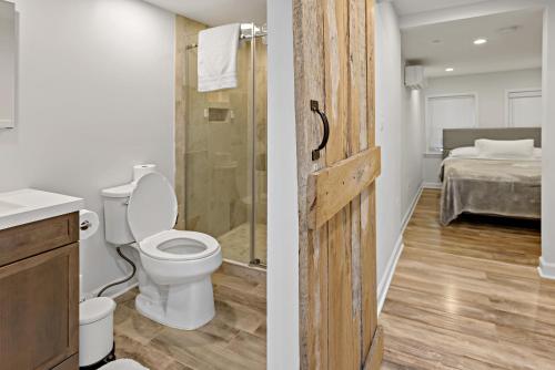 a bathroom with a toilet and a shower and a bedroom at Boutique Blue 2 bedroom Old Town House in Alexandria