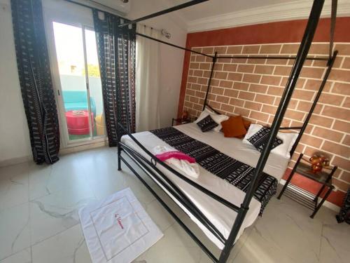 a bedroom with a bunk bed and a brick wall at La Villeneuvoise in Mbour