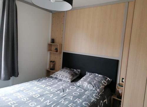 - une chambre avec un lit et deux oreillers dans l'établissement Cottage chaleureux Louann, à Labouheyre