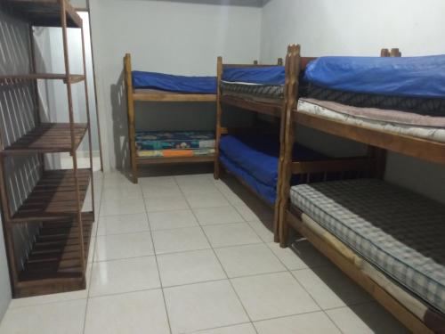 Cette chambre comprend 3 lits superposés et du carrelage. dans l'établissement Casa em Mongaguá, próximo a Plataforma de Pesca, à Mongaguá