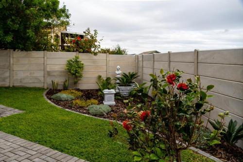a backyard with a fence and a garden with flowers at Verdant Hills in Reebok