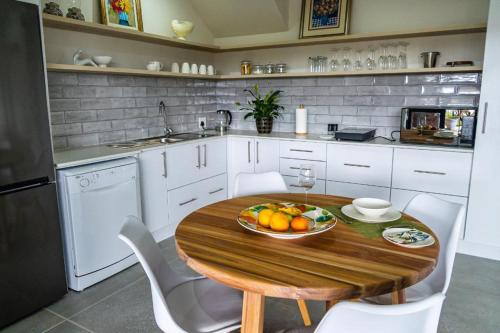 a kitchen with a wooden table with a bowl of fruit on it at Verdant Hills in Reebok