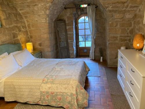 - une chambre avec un grand lit dans un bâtiment en pierre dans l'établissement Idyllic French farmhouse, à Les Assions