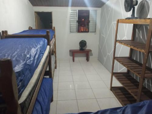 a room with two bunk beds and a table at Casa em Mongaguá, próximo a Plataforma de Pesca in Mongaguá