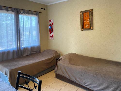 Habitación con 2 camas y ventana con en DEPARTAMENTO DON GENARO en Villa Carlos Paz