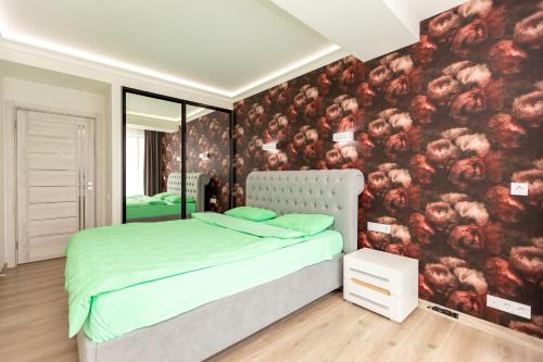 キシナウにあるLuxury Apartmentの花で覆われた壁、ベッド付きのベッドルーム1室が備わります。