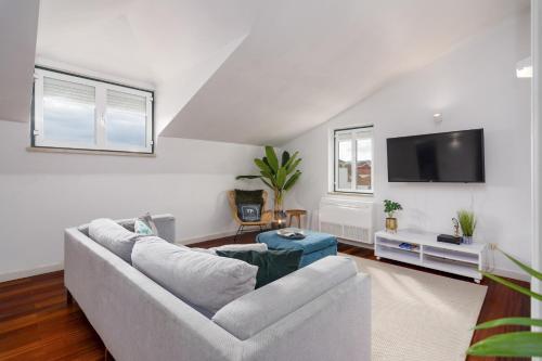 a living room with a couch and a flat screen tv at Setubal Downtown N97, By Home Match in Setúbal