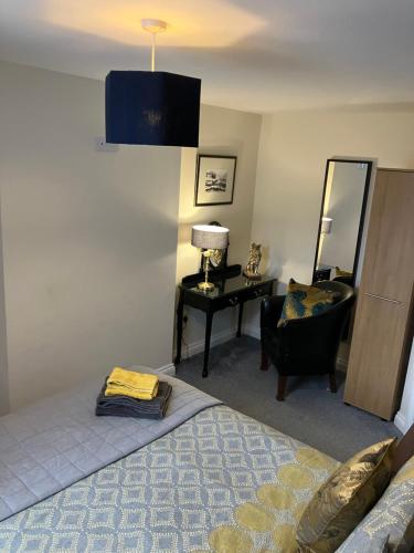 a bedroom with a bed and a chair and a mirror at THE OCEAN SUITE - 2 minute walk to the lovely beach front promernade of llandudno in Llandudno