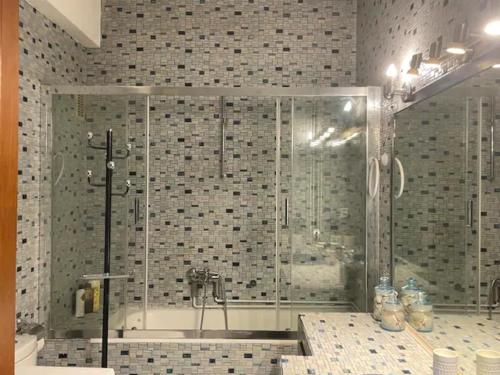 a bathroom with a shower and a tub at Athens Neos Kosmos penthouse, sea and city view in Athens