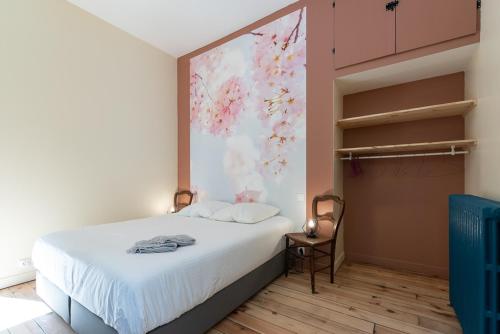 1 dormitorio con 1 cama y una pintura en la pared en Gites de La Soulière, en Aubin
