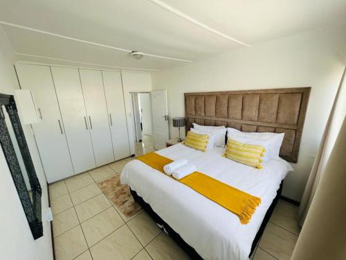 a bedroom with a large bed with yellow and white pillows at Safi Luxury Self-Catering Suite 8 in East London