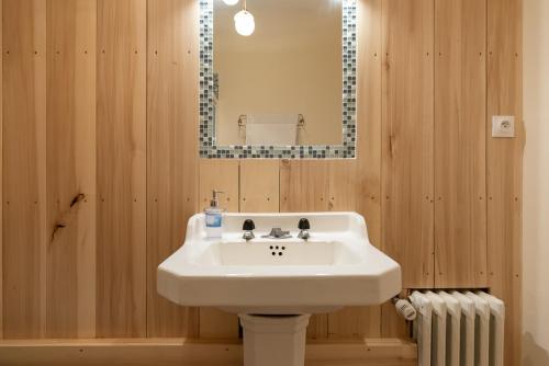 y baño con lavabo blanco y espejo. en Gites de La Soulière, en Aubin