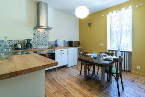 a kitchen with a table and a wooden floor at Gites de La Soulière in Aubin