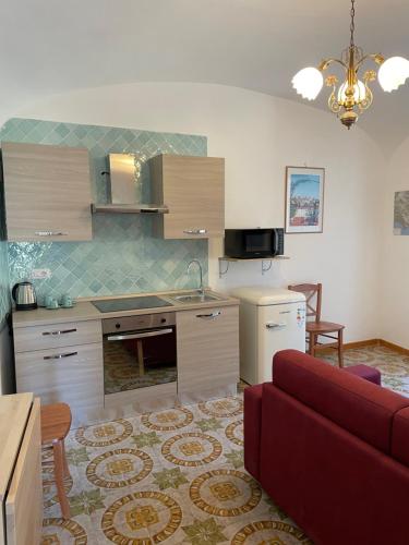 a kitchen and living room with a red couch at Il Gelso Bianco -The White Mulberry Tree in Ravello