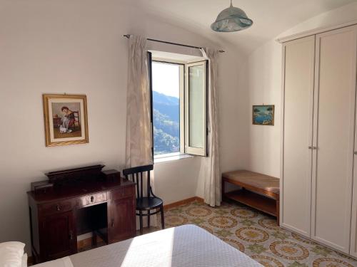 Schlafzimmer mit einem Fenster, einem Schreibtisch und einem Bett in der Unterkunft The White Mulberry Tree in Ravello