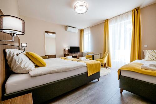 a hotel room with a large bed and a desk at Fürdő Hotel*** Zalakaros in Zalakaros