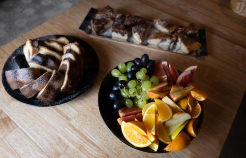 two plates of food on a wooden table with fruit at Hotel Stračena City in Ostrava