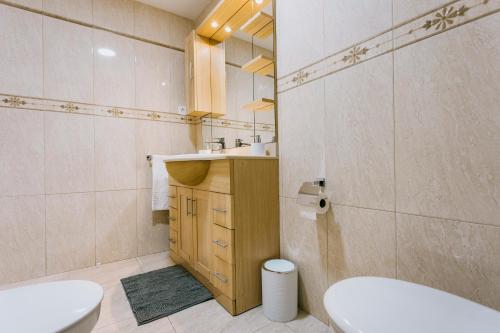 a bathroom with a white toilet and a sink at A Casa Martinez Playa Sin Ascensor in Mareny Barraquetas