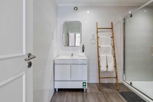 y baño blanco con lavabo y ducha. en Omega Apartment, en Setúbal