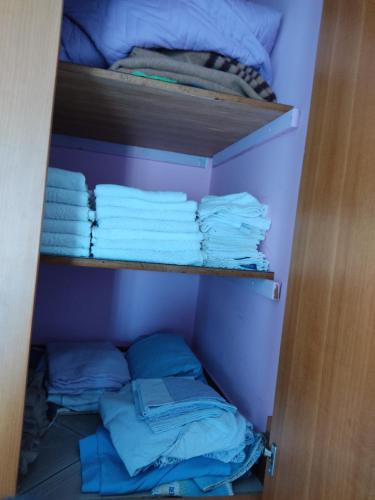 un armario con toallas azules y una pila de toallas en Villa Lucia Anna, en Scalo dei Saraceni Manfredonia