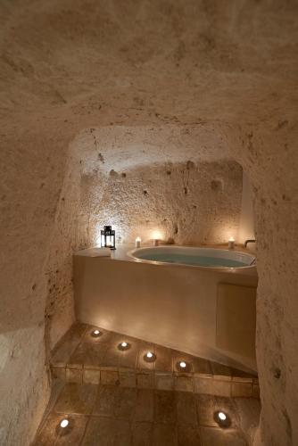 - une salle de bains en pierre avec une baignoire dans une grotte dans l'établissement Ai Terrazzini, à Matera