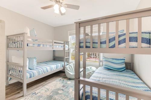 een slaapkamer met een stapelbed en een plafondventilator bij Ruff-Tide in Oak Island