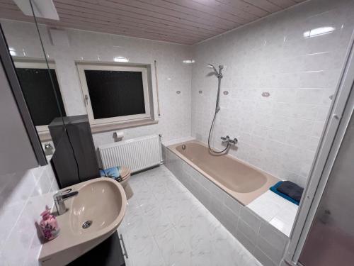 La salle de bains est pourvue d'une baignoire, d'un lavabo et d'une douche. dans l'établissement Familie Ising, à Unterwörnitz